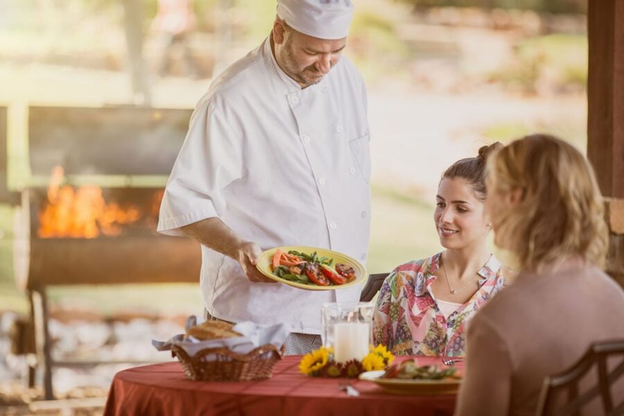 Chef at Enterhealth Ranch inpatient rehab presenting patient with delicious plate of food.