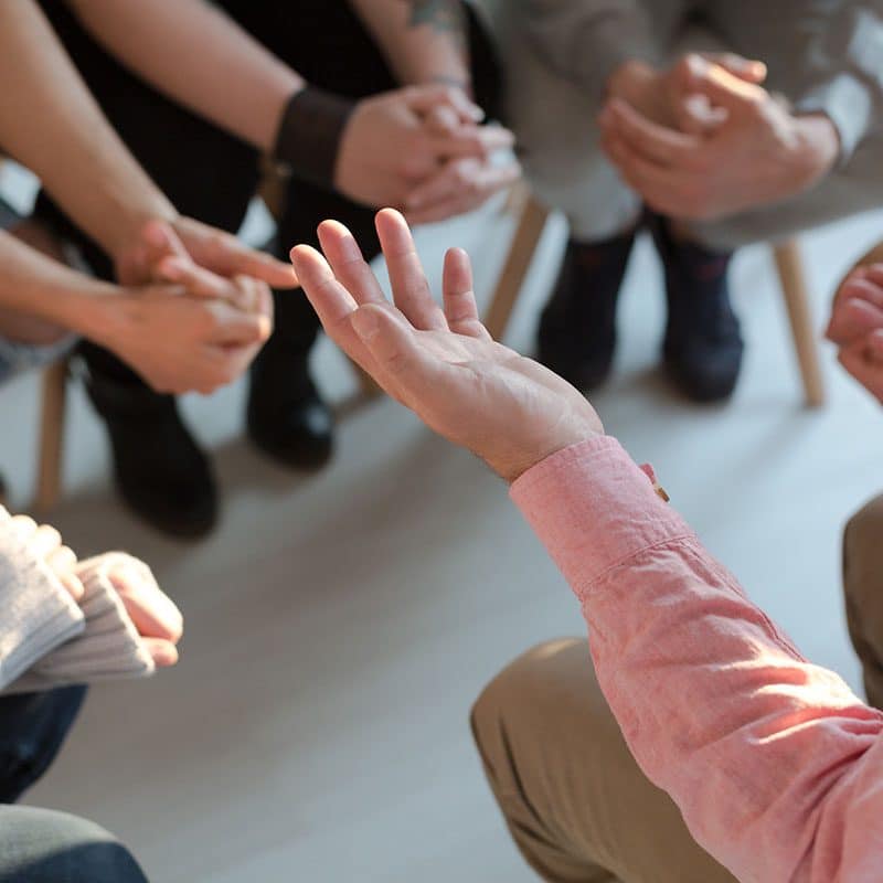 People gathered in a circle for group therapy in intensive outpatient programs.