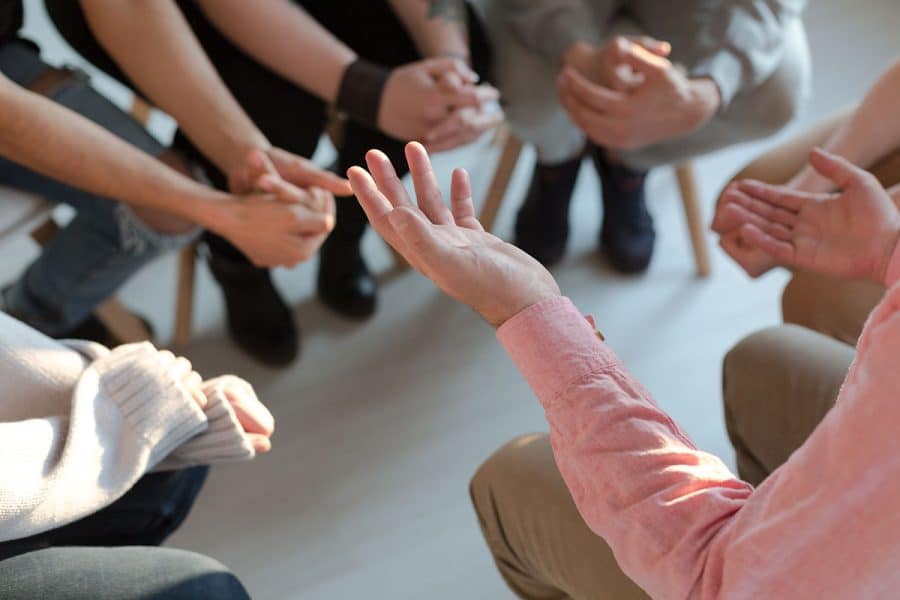 People gathered in a circle for group therapy in intensive outpatient programs.