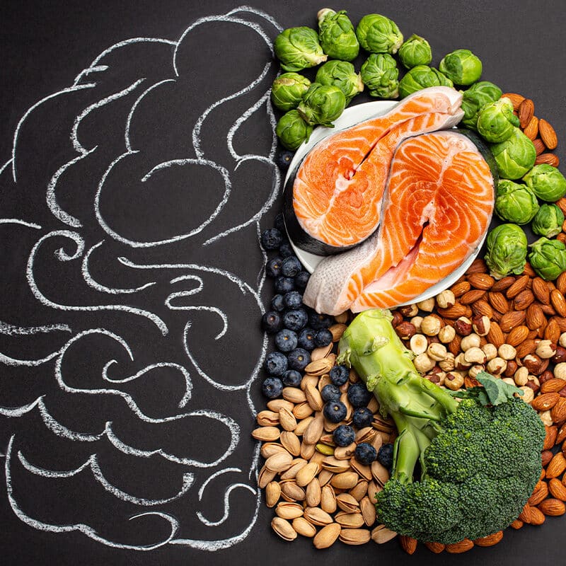 Split image with a chalk drawing of a brain on the left and a cluster of healthy foods on the right.